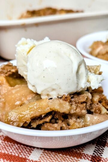 baked apple cobbler from scratch recipe serving in bowl with a scoop of ice cream